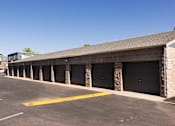 Thumbnail 16 of 39 - the outside of a building with garages and a parking lot