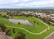 Thumbnail 34 of 34 - an aerial view of a park with a pond and a city in the background