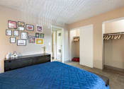 Thumbnail 6 of 34 - a bedroom with a blue bed and a closet