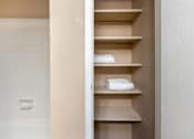 Thumbnail 8 of 34 - a bathroom with a closet with white towels