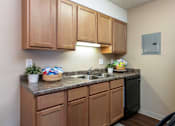 Thumbnail 4 of 34 - our apartments have a kitchen with a black refrigerator and a sink