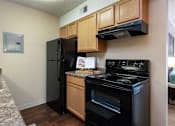 Thumbnail 3 of 34 - a kitchen with black appliances and wooden cabinets and a black refrigerator