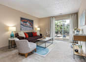 Thumbnail 1 of 34 - a living room with a couch and a table   and a balcony