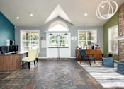 Thumbnail 28 of 34 - a reception area with a desk and chairs and a glass door