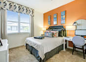 Thumbnail 12 of 31 - A bedroom with a bed, desk, chair, and window.