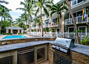 Thumbnail 21 of 31 - an outdoor kitchen with a grill and a swimming pool