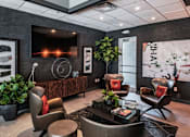 Thumbnail 28 of 31 - a lobby with chairs and a table and a television