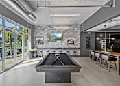 Thumbnail 26 of 31 - a pool table in a living room with a bar and a view of a lake