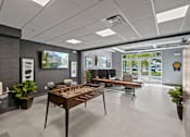 Thumbnail 27 of 31 - a game room with a foosball table and other furniture