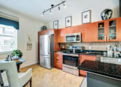 Thumbnail 4 of 31 - a kitchen with wooden cabinets and stainless steel appliances and a table and chairs