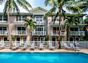 Thumbnail 19 of 31 - a large swimming pool in front of a building with palm trees