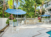 Thumbnail 20 of 31 - a patio with tables and umbrellas next to a pool