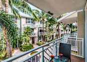 Thumbnail 8 of 31 - a balcony with a patio and palm trees