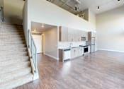 Thumbnail 10 of 30 - A spacious living room with a staircase on the left side.