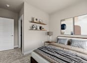 Thumbnail 6 of 39 - A bedroom with a bed, nightstand, lamp, and shelves.