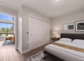 Thumbnail 17 of 39 - A bedroom with a large bed and a sliding door leading to a balcony.