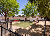 Thumbnail 27 of 43 - a fenced in dog park with grass and benches