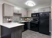 Thumbnail 7 of 43 - a kitchen with black appliances and a white counter top