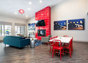Thumbnail 72 of 87 - a living room with a red accent wall and a dining room table and chairs