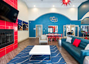Thumbnail 74 of 87 - a living room with a blue couch and a table and a fireplace
