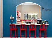 Thumbnail 66 of 87 - a bar with four red stools in front of a counter with red chairs