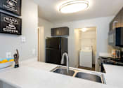 Thumbnail 12 of 87 - a kitchen with a sink and a counter and a refrigerator