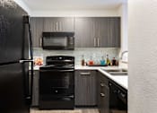 Thumbnail 1 of 87 - a kitchen with black appliances and dark wood cabinets