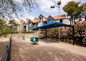 Thumbnail 79 of 87 - a park with a playground and a blue canopy