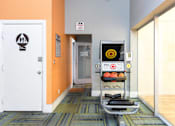 Thumbnail 42 of 87 - a gym with a punching bag and weights in a room with a door