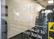 Thumbnail 45 of 87 - a weight room sign on the door of a gym with escalators