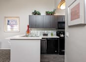Thumbnail 27 of 87 - a kitchen with black appliances and a counter top