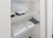 Thumbnail 33 of 87 - a white closet with shelves filled with folded white towels and pillows