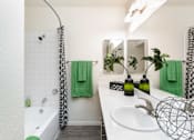 Thumbnail 19 of 43 - a bathroom with a tub and a sink and a mirror