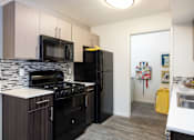 Thumbnail 21 of 43 - a kitchen with black appliances and a black refrigerator