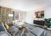 Thumbnail 2 of 43 - a living room with a gray couch and a tv