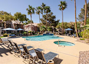 Thumbnail 28 of 43 - a swimming pool with chairs and umbrellas and palm trees