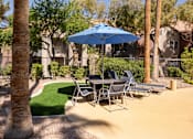 Thumbnail 30 of 43 - a patio with a table and chairs and an umbrella