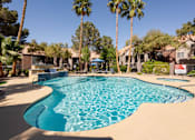 Thumbnail 31 of 43 - a large swimming pool with palm trees and houses in the background