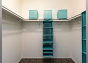 Thumbnail 23 of 54 - a walk in closet with blue shelves and white walls