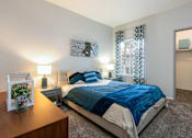 Thumbnail 21 of 54 - a bedroom with a bed and a dresser and a mirror