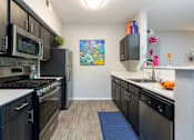 Thumbnail 8 of 54 - a kitchen with black cabinets and stainless steel appliances and a sink