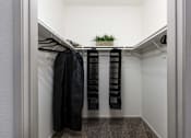 Thumbnail 15 of 54 - a walk in closet with robes and a plant in it
