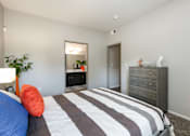 Thumbnail 16 of 54 - a bedroom with a bed and a dresser and a bathroom