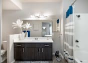 Thumbnail 23 of 47 - a bathroom with a shower and a sink and a mirror