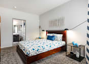 Thumbnail 22 of 47 - a bedroom with a bed and a dresser and a bathroom