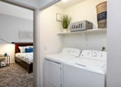 Thumbnail 18 of 47 - a white washer and dryer in a room with a bedroom
