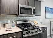 Thumbnail 6 of 47 - a kitchen with a stove and a microwave