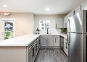 Thumbnail 27 of 36 - a kitchen with white cabinets and a stainless steel refrigerator