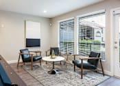 Thumbnail 24 of 36 - a living room with chairs and a table and large windows