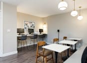 Thumbnail 28 of 36 - a dining room with tables and chairs and a counter with lamps